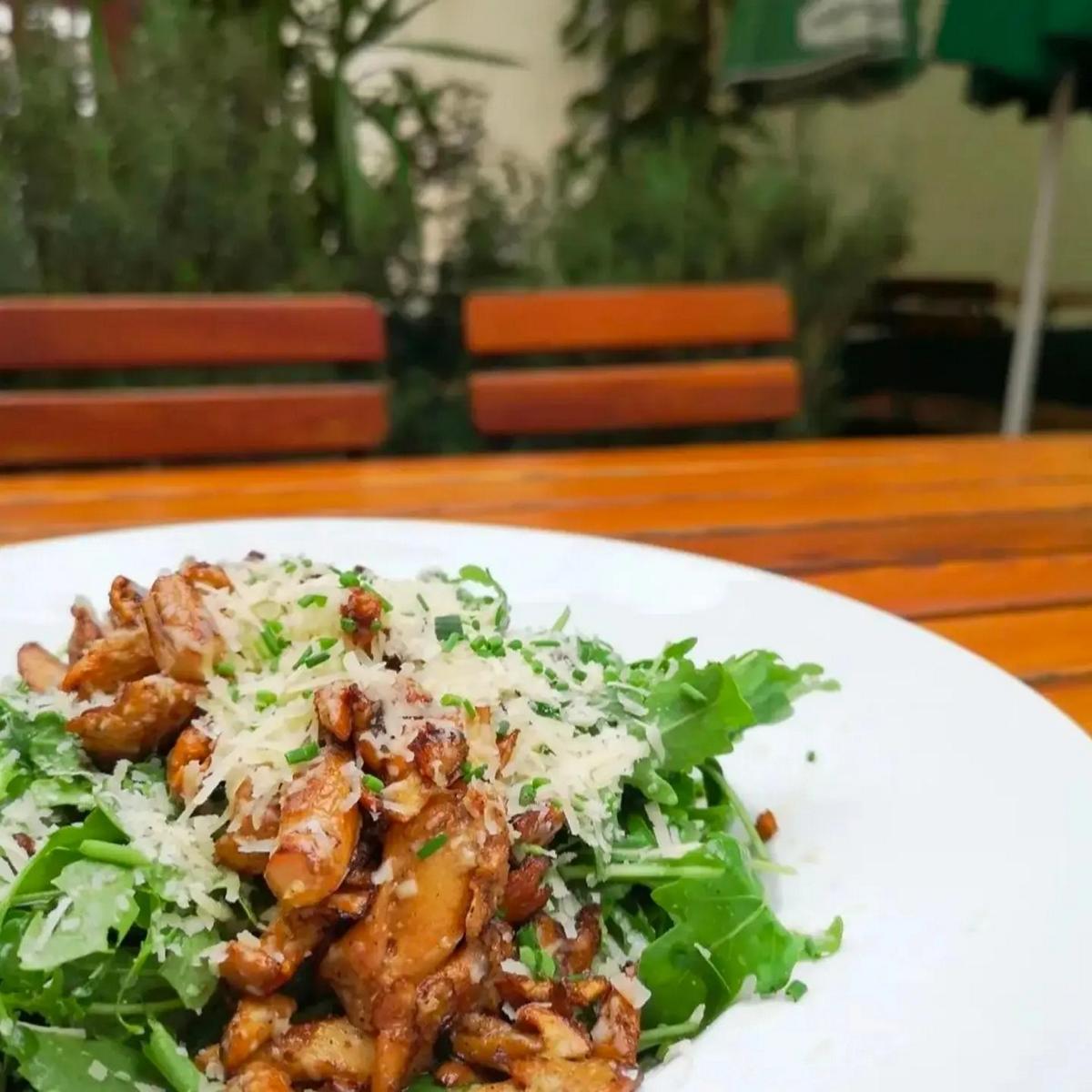 Gebratene Eierschwammerl auf Rucola im Gastgarten des Lercherl